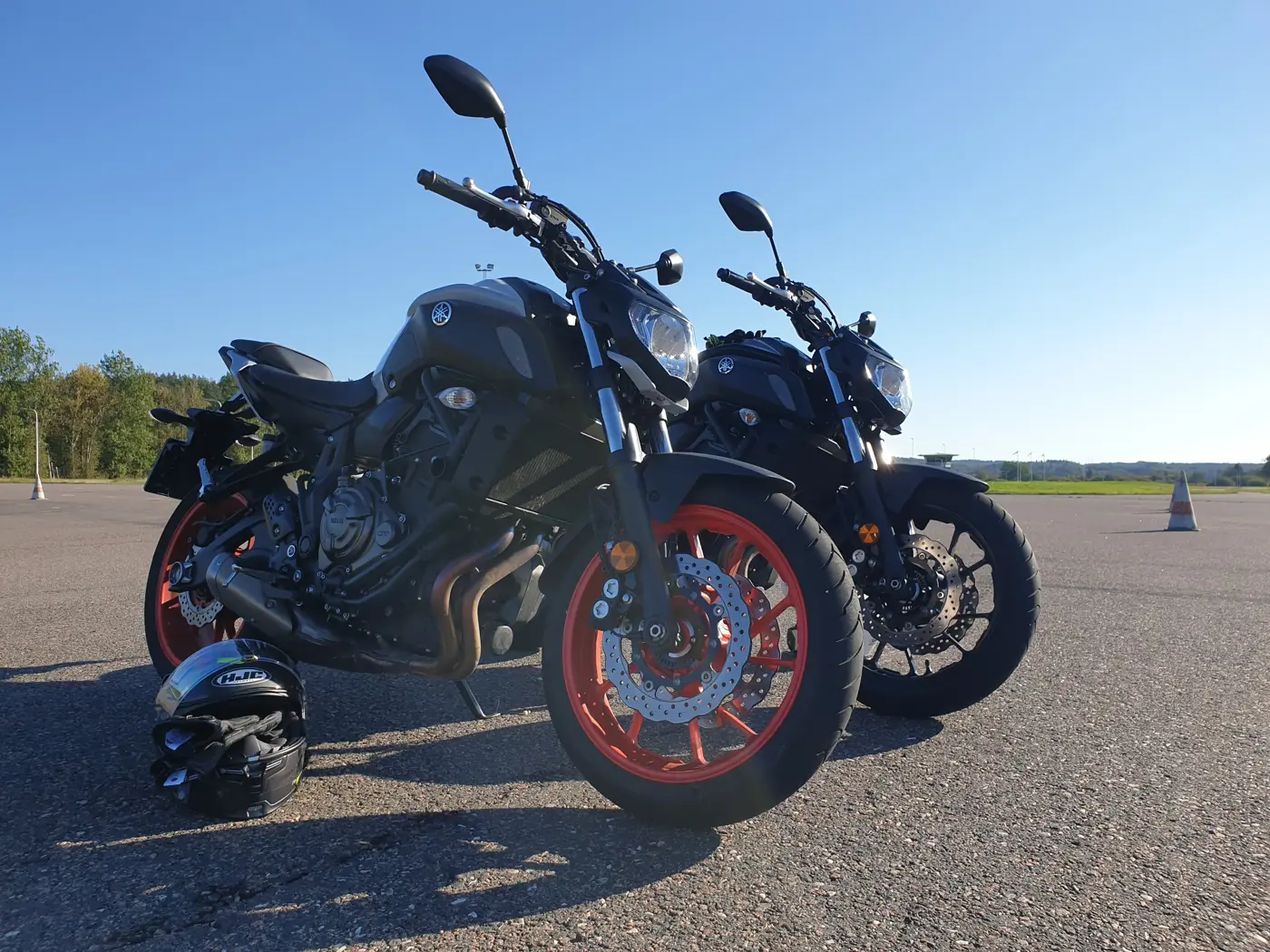 Två motorcyklar som står på en alfaltsplan