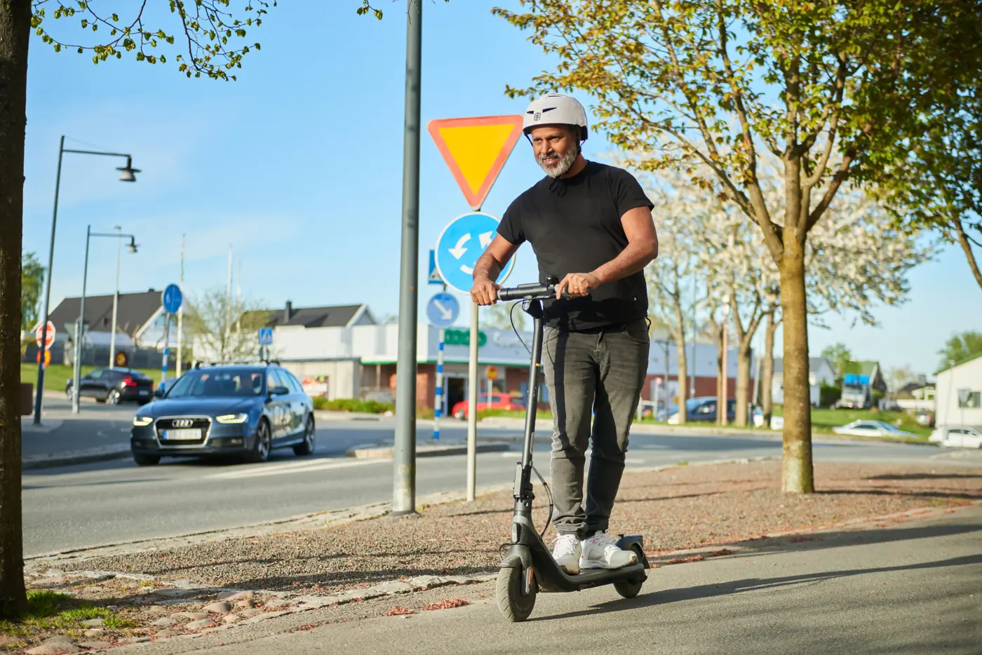En man kör elsparkcykel.