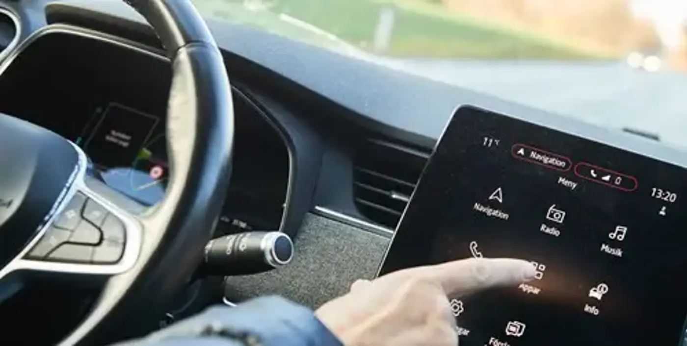 en zoomad bild på en man som tar på en skärm i bilen