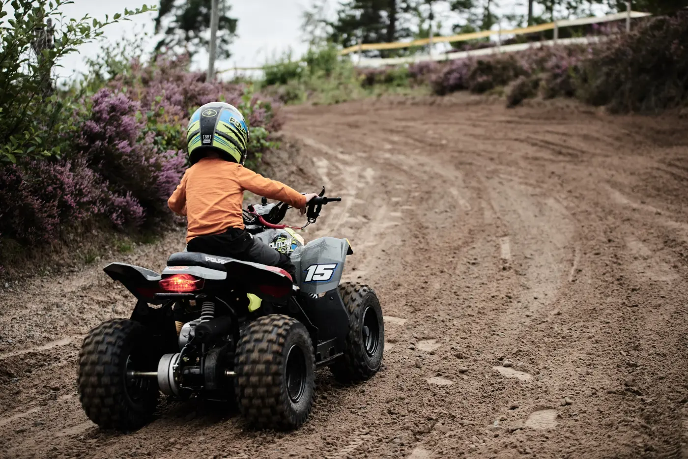 Ett barn kör på en terrängbana med en fyrhjuling