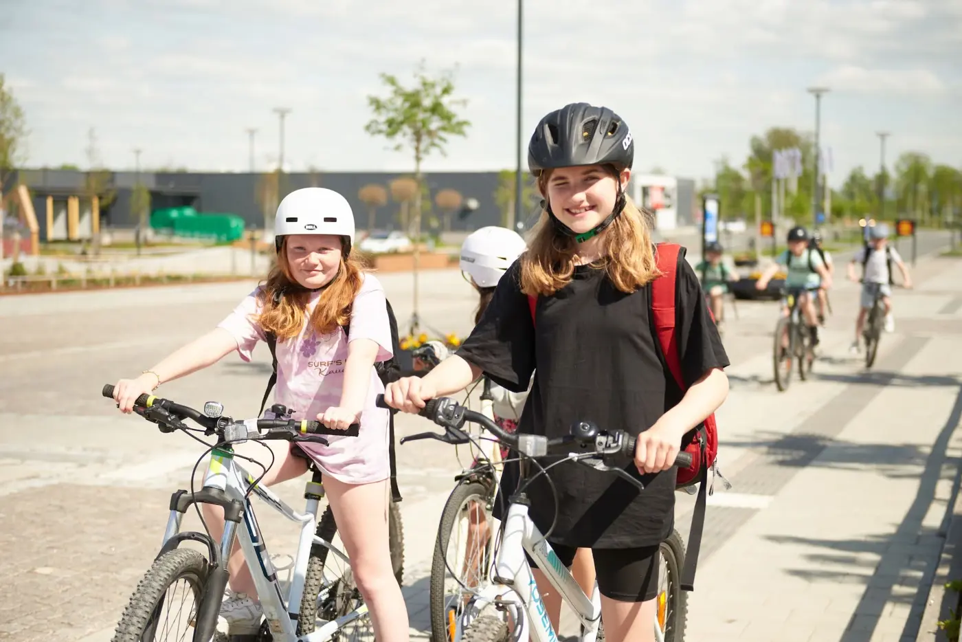 Några barn i tolvårsåldern cyklar på en gång-och cykelbana