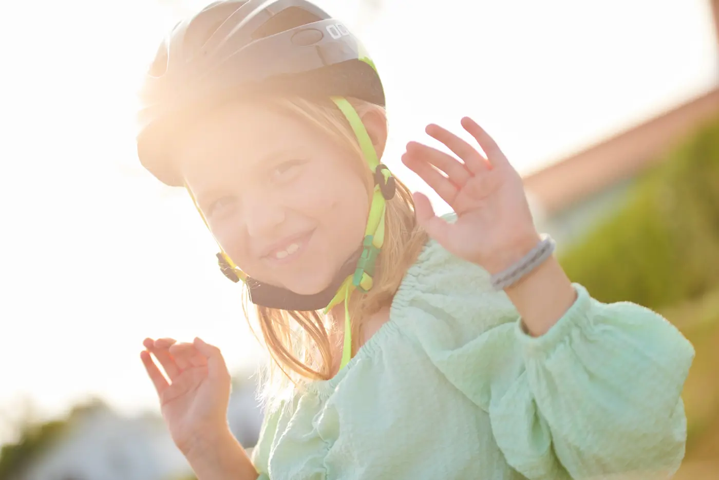En närbild på ett barn med en cykelhjälm med grönt spänne.