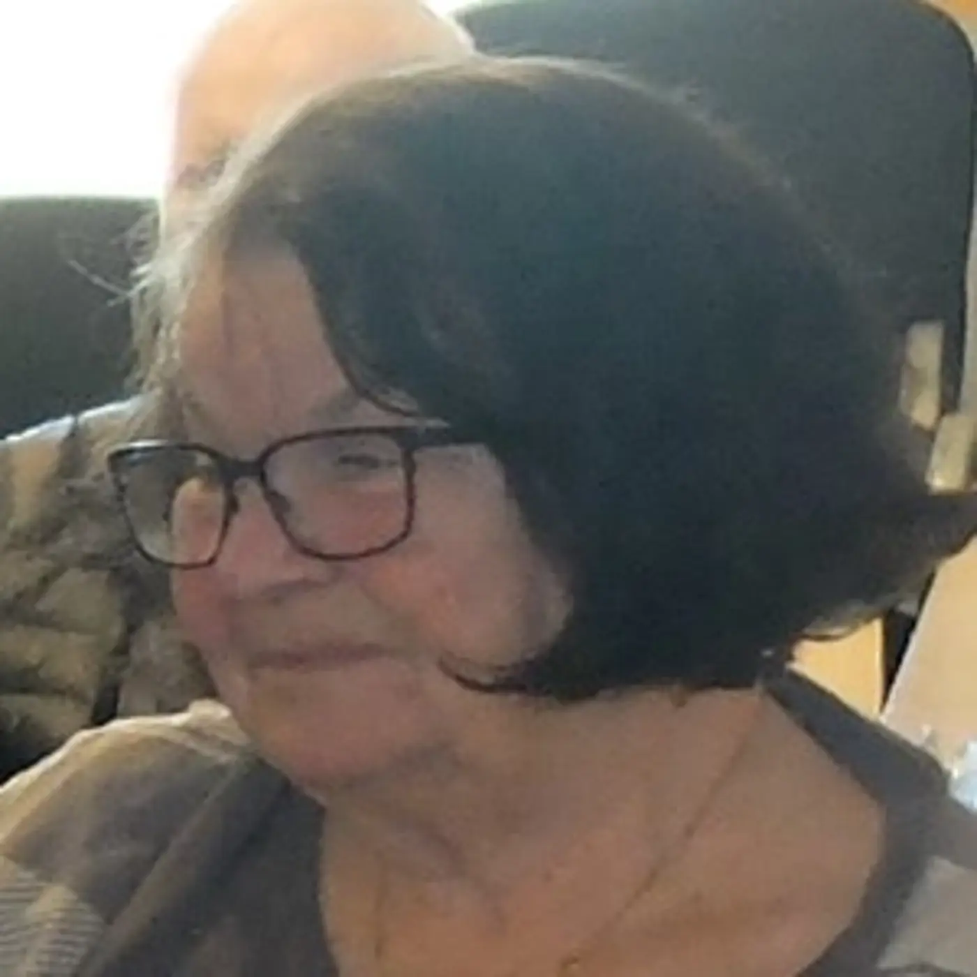 En porträttbild på en äldre kvinna med kort hår och glasögon.