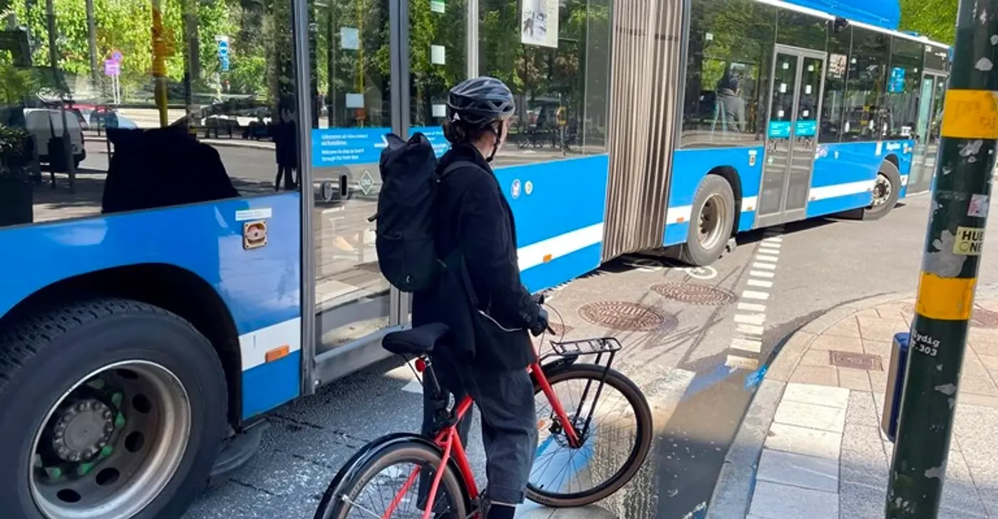 En cykel väntar på en buss som svänger.