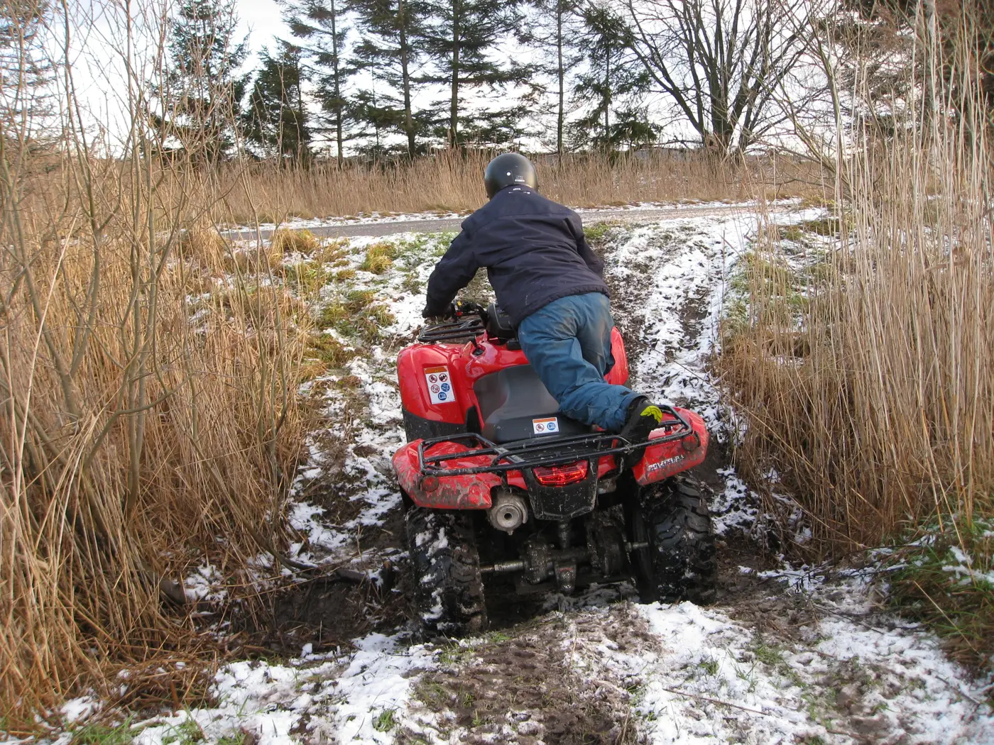 En person kör en fyrhjuling i terräng