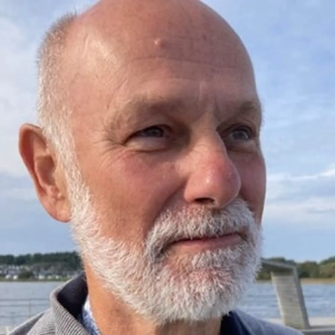 Porträttbild på en man med kort vitt skägg.
