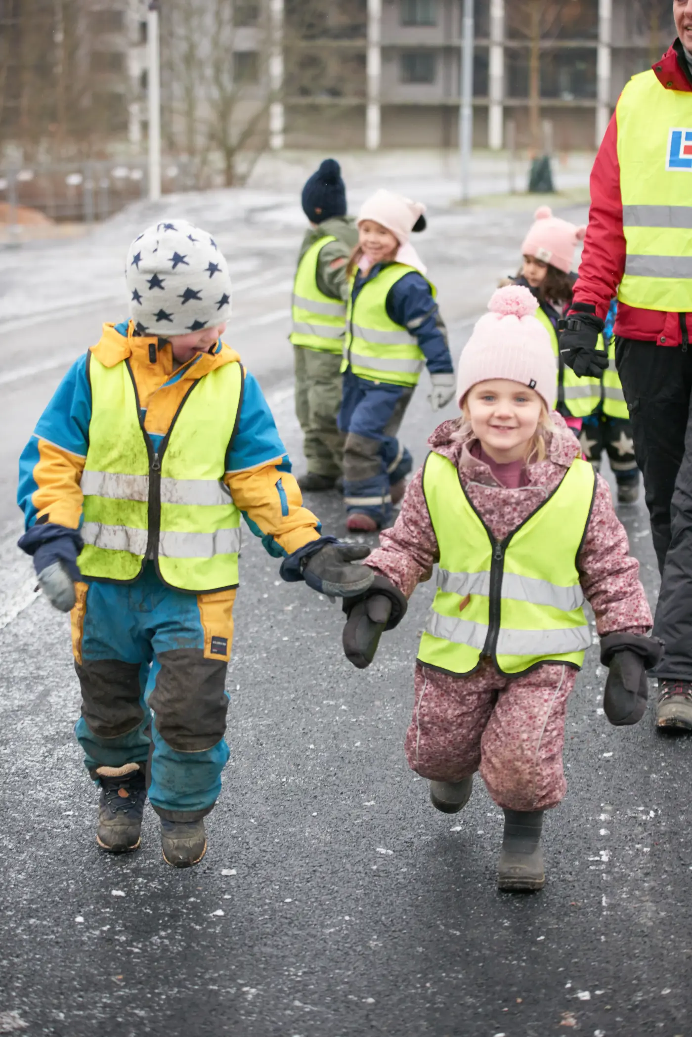 En grupp förskolebarn med regnkläder och reflexväst