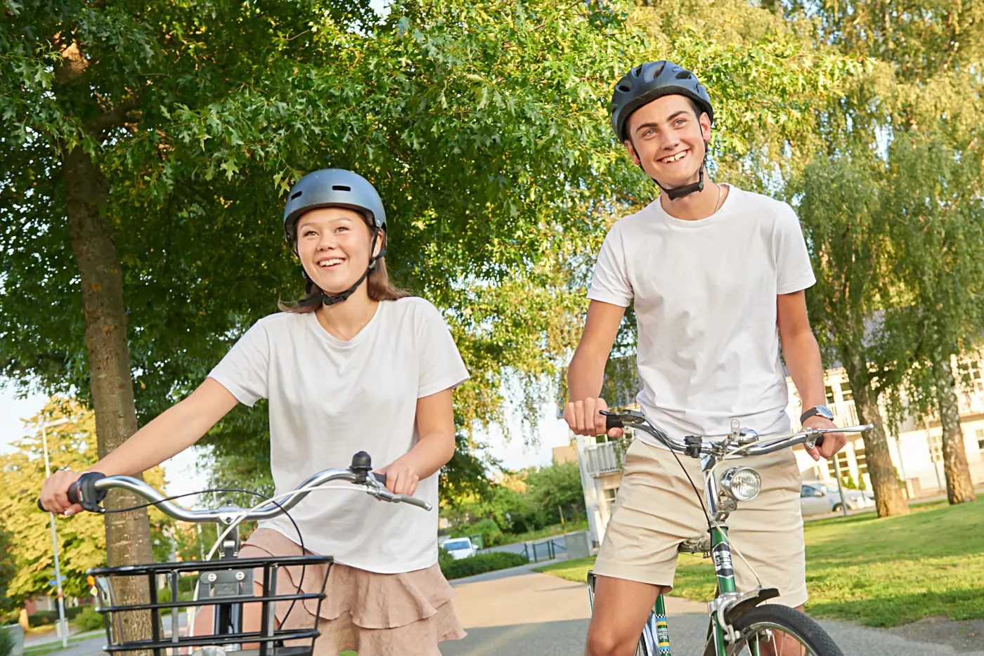 Två tonåringar står med varsin cykel och hjälm på huvudet
