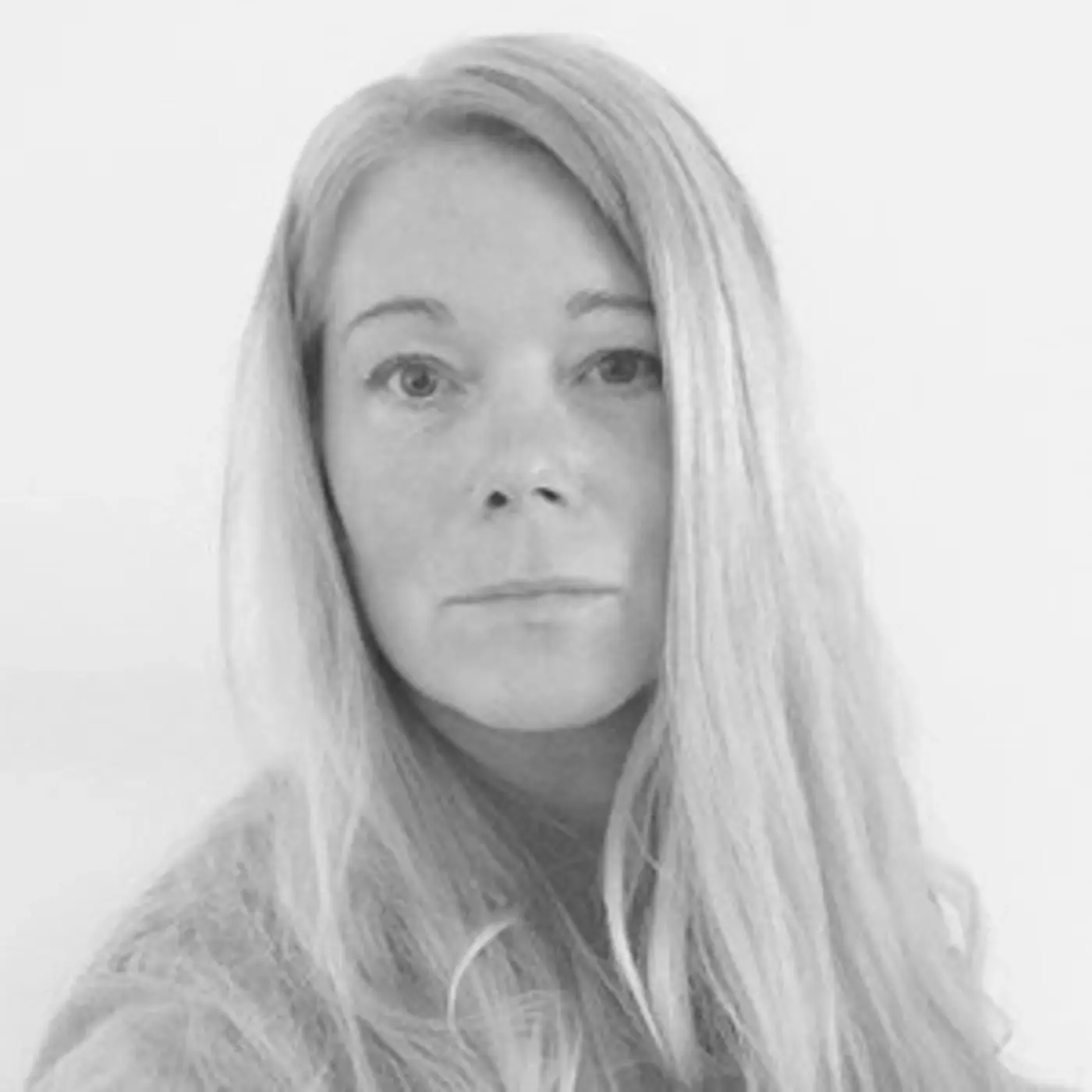 Svartvit porträttbild på en kvinna med långt, blont hår.