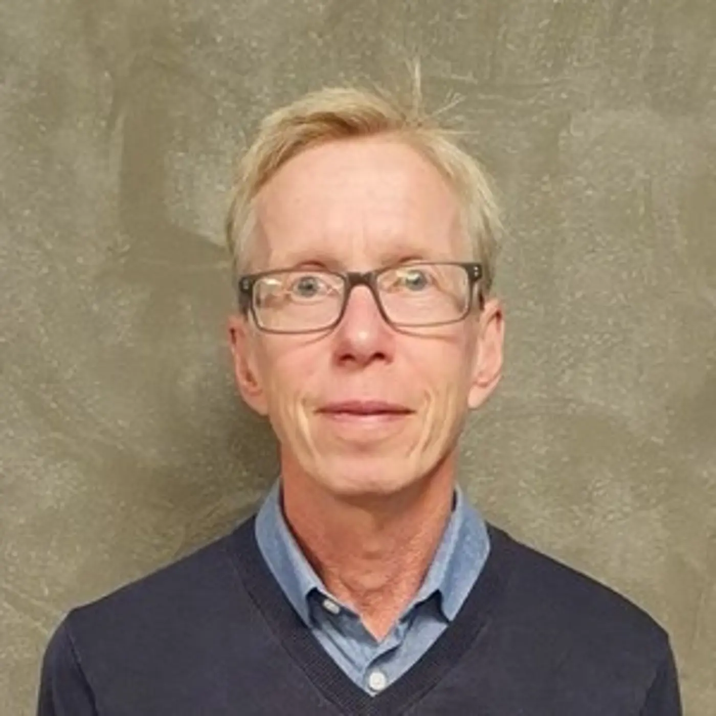 Porträttbild på en äldre man med glasögon.