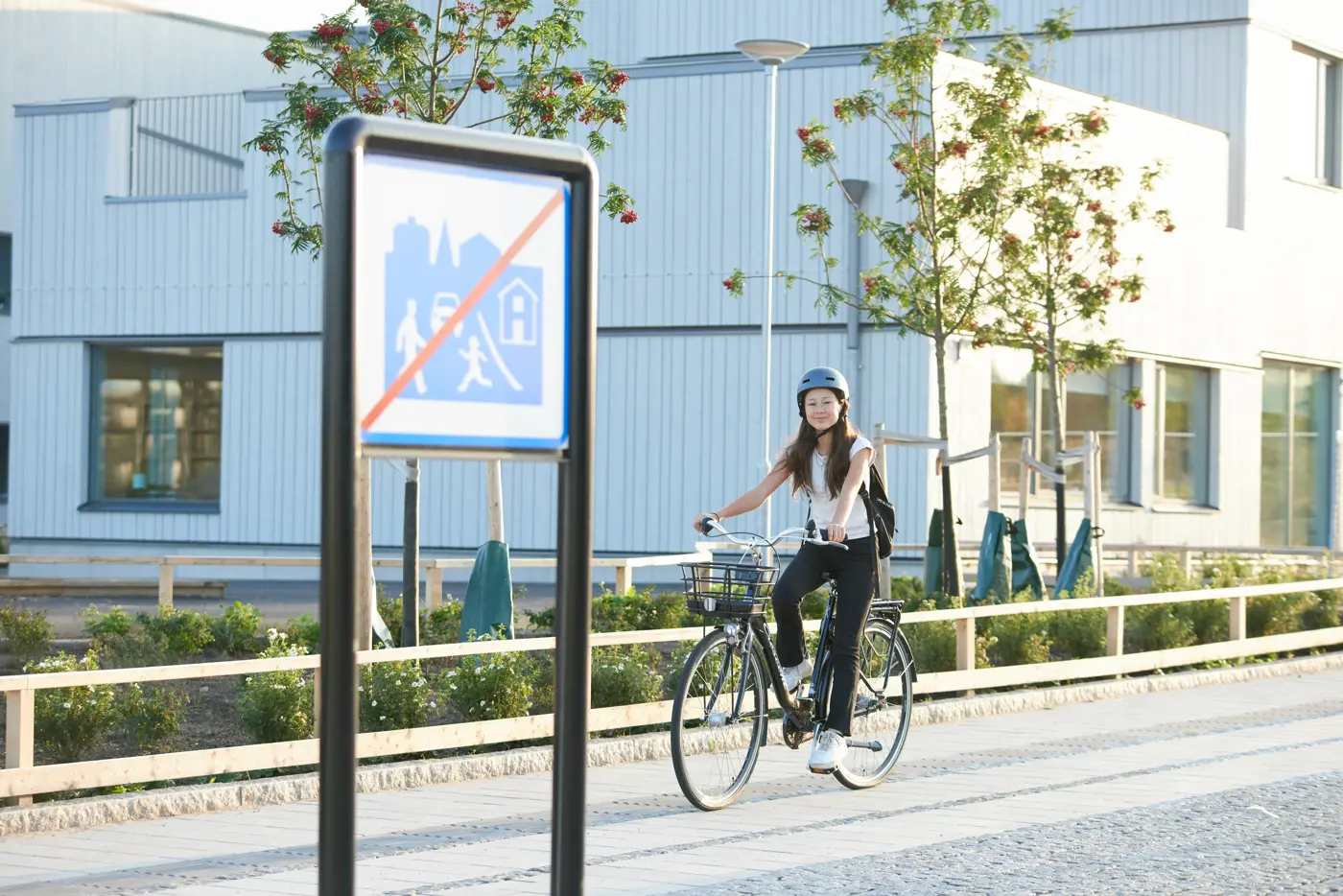 Ett skolbarn cyklar utanför en skola