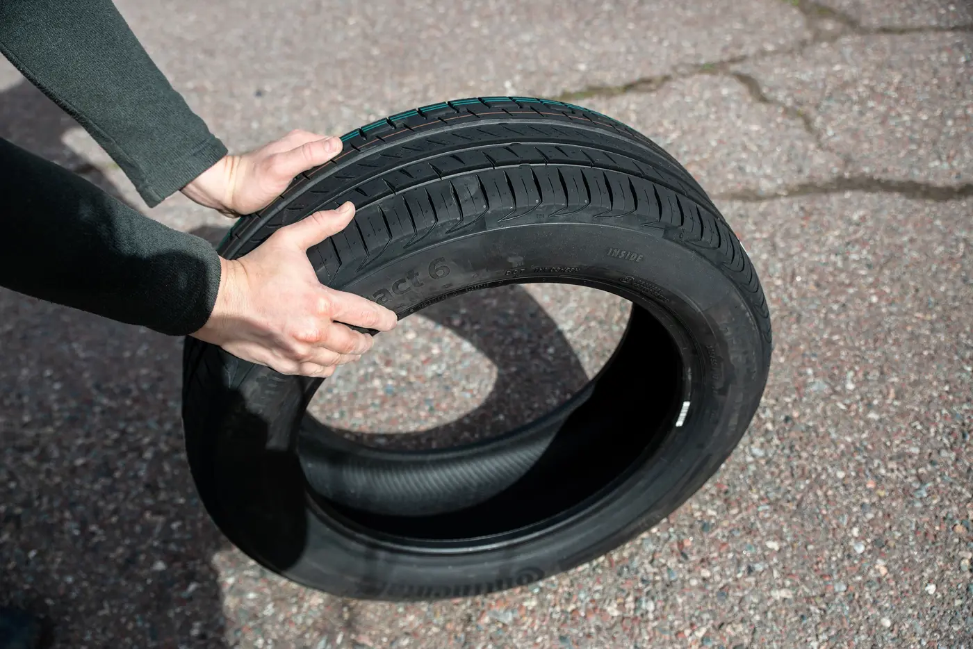 En person håller i ett bildäck.