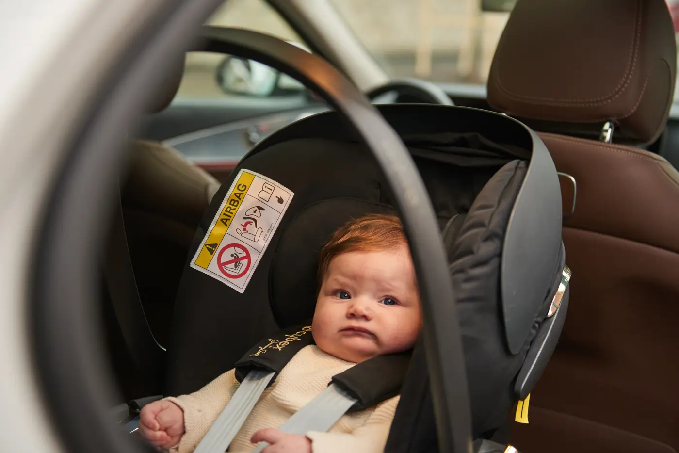 En bebis ligger i ett babyskydd.