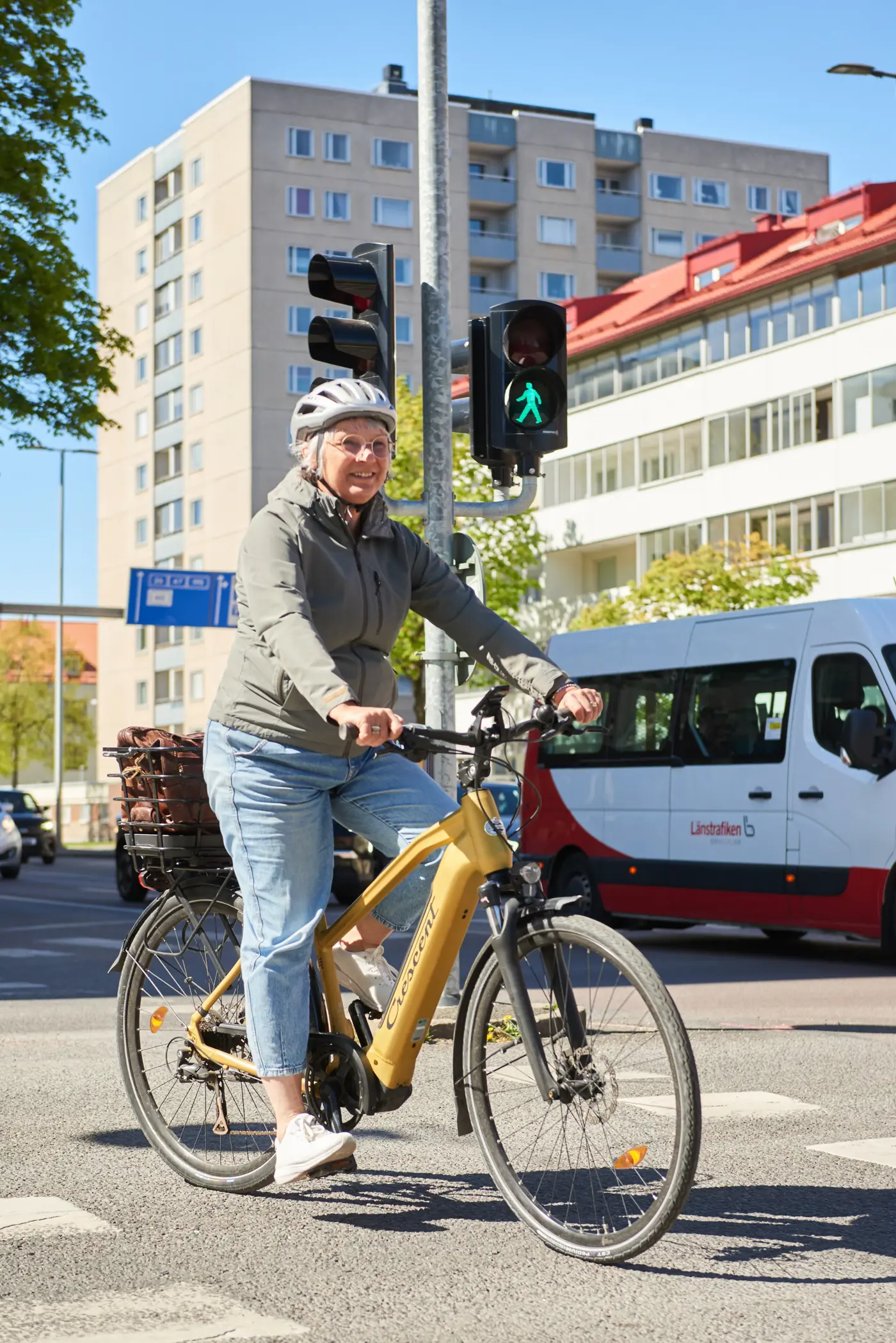 En äldre kvinna cyklar över ett övergångsställe.