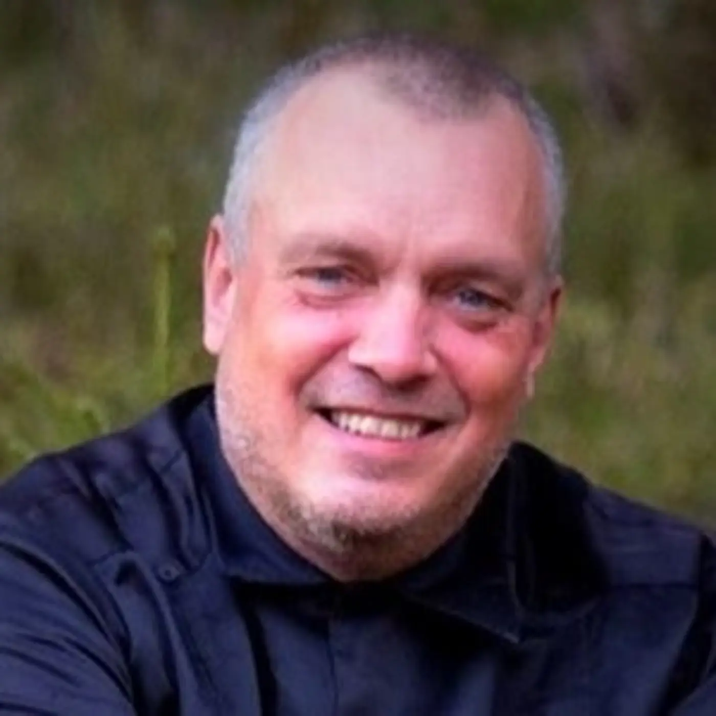 En porträttbild på en man som ler mot kameran.