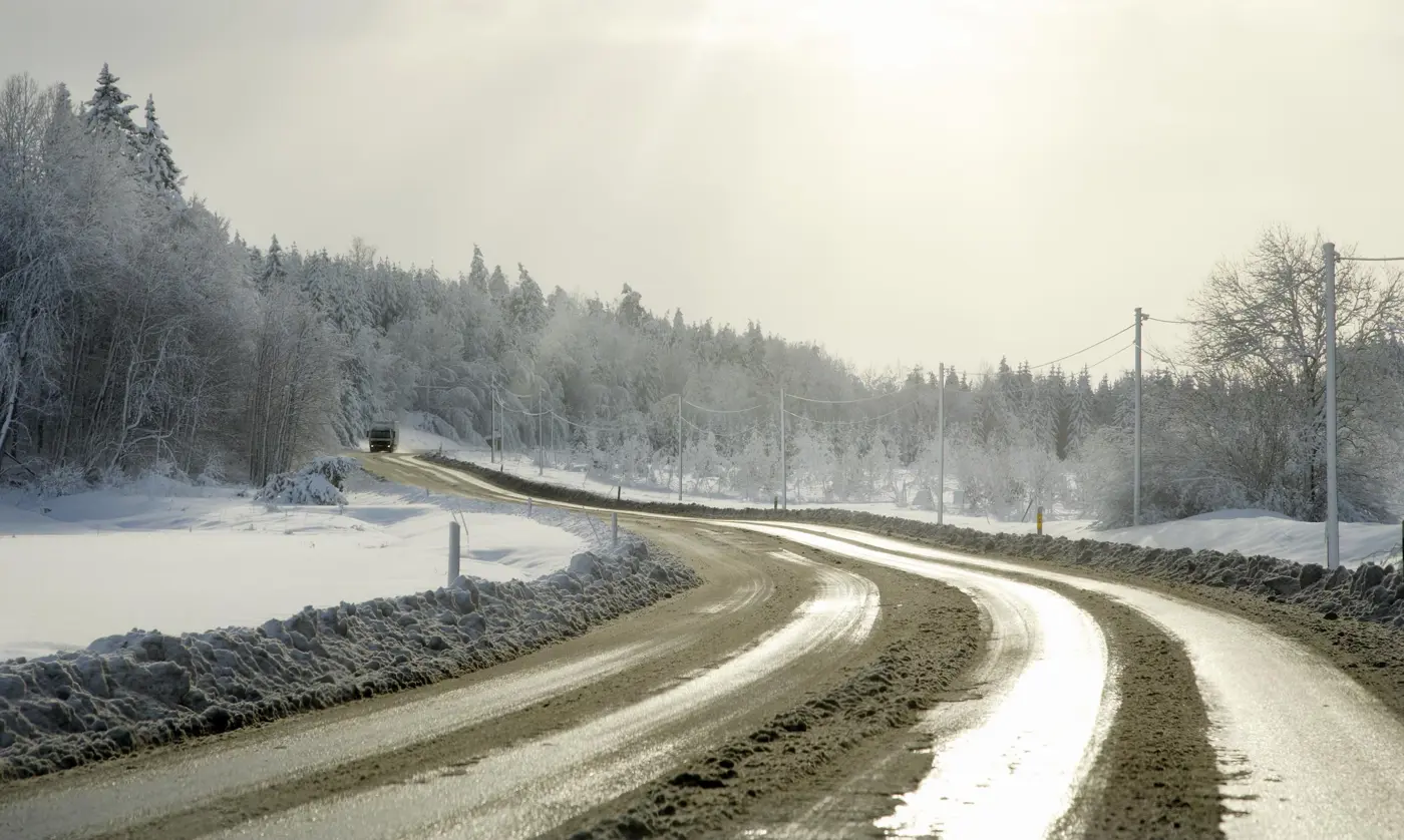 En väg i vintermiljö med slask på asfalten