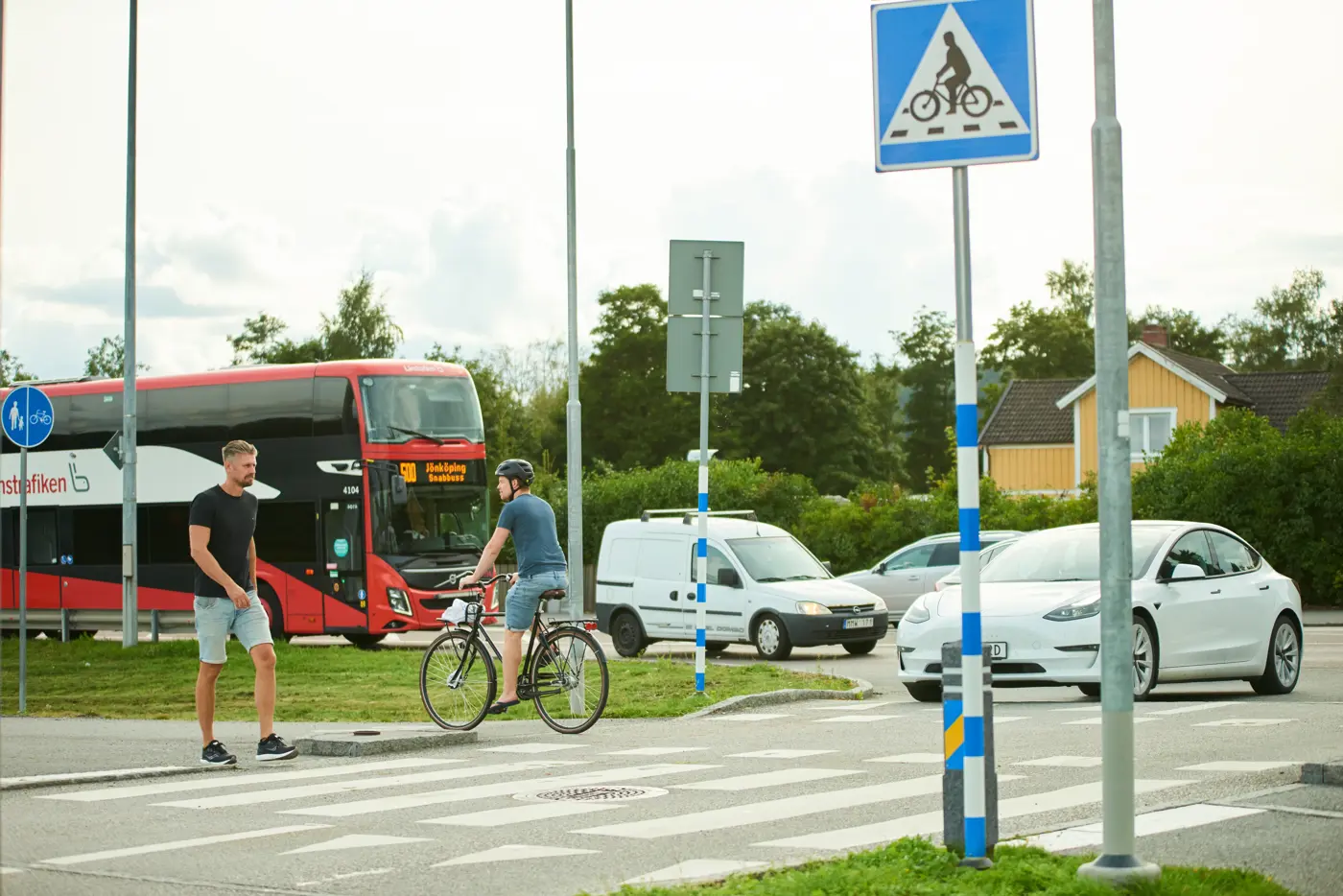 En person cyklar över en cykelpassage och en person går över ett övergångsställe.