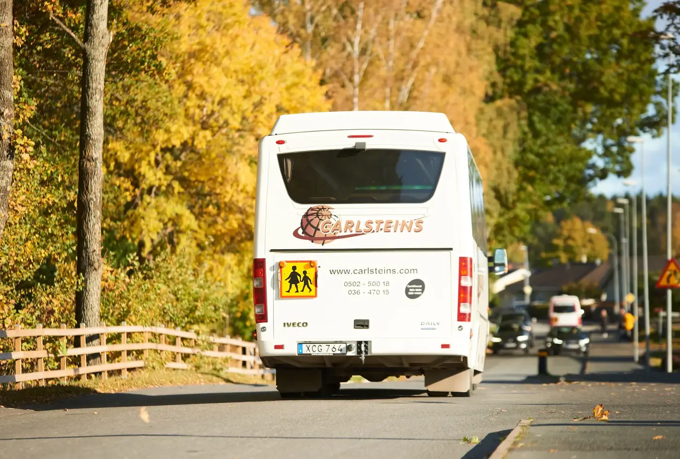 Baksidan av en skolbuss som kör på en väg 