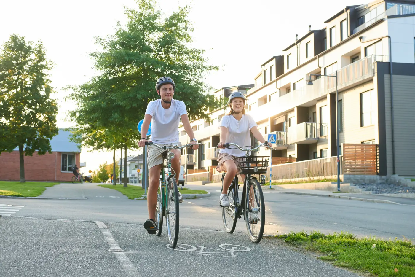 Två tonåringar kommer cyklandes på en cykelbana.
