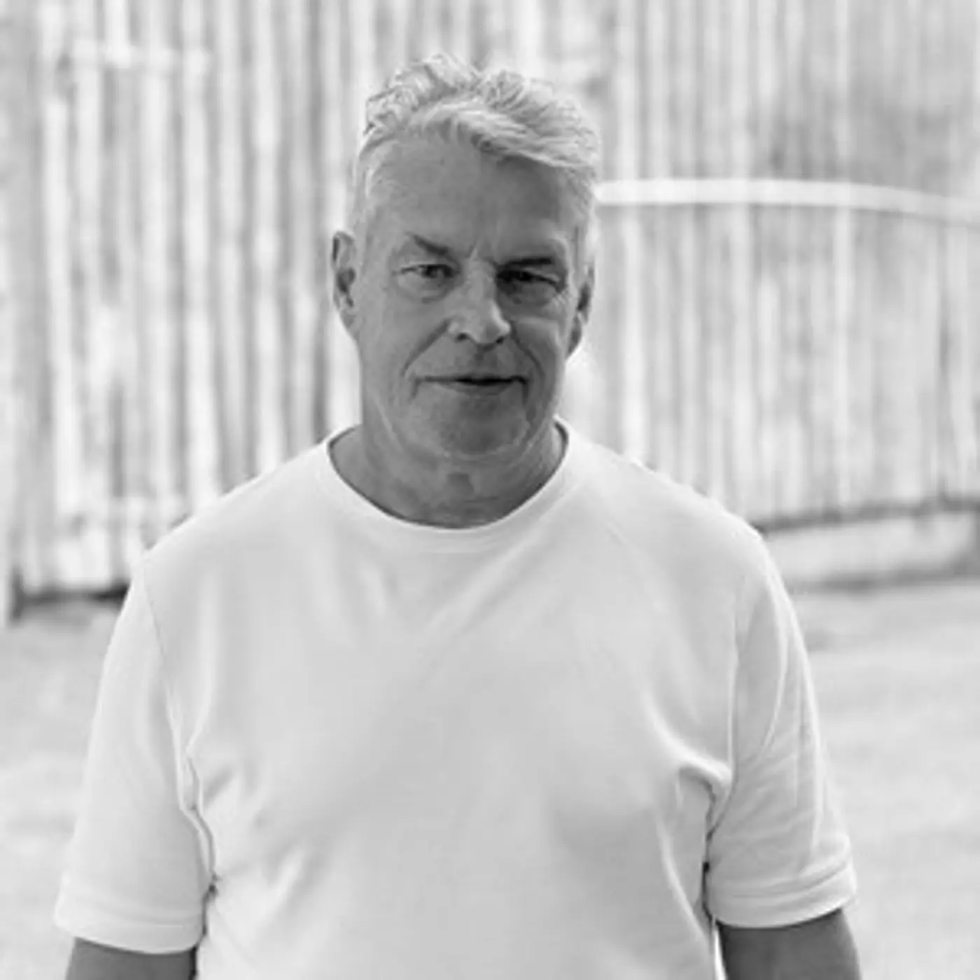 Svartvit porträttbild på en man med vit t-shirt.