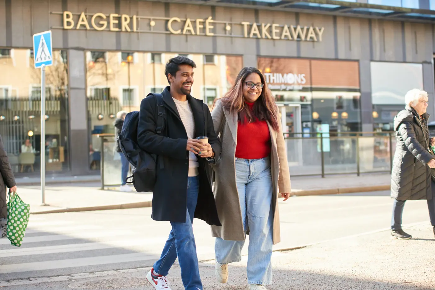 Två vuxna går över ett övergångsställe