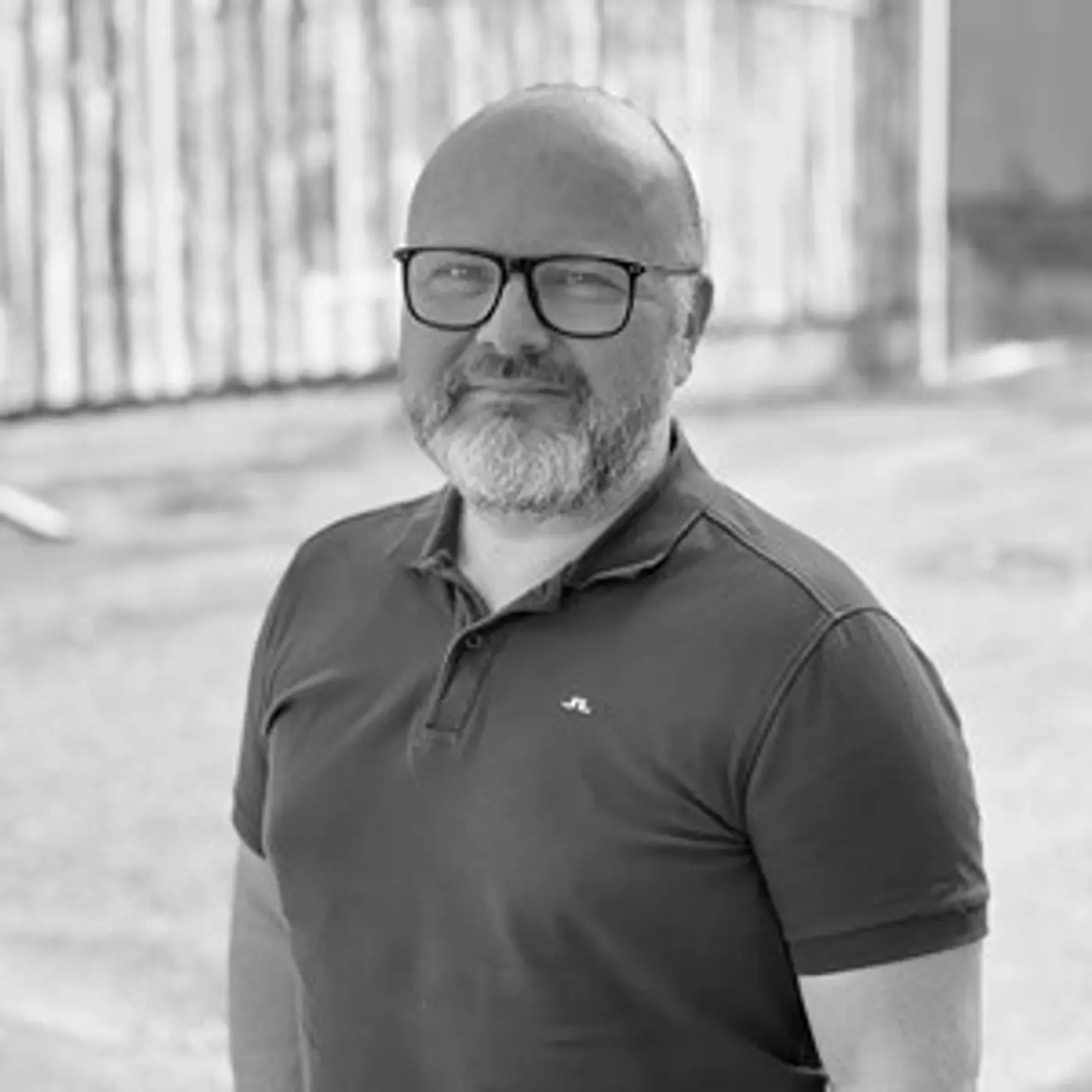 Svartvit porträttbild på en man med glasögon och skägg.