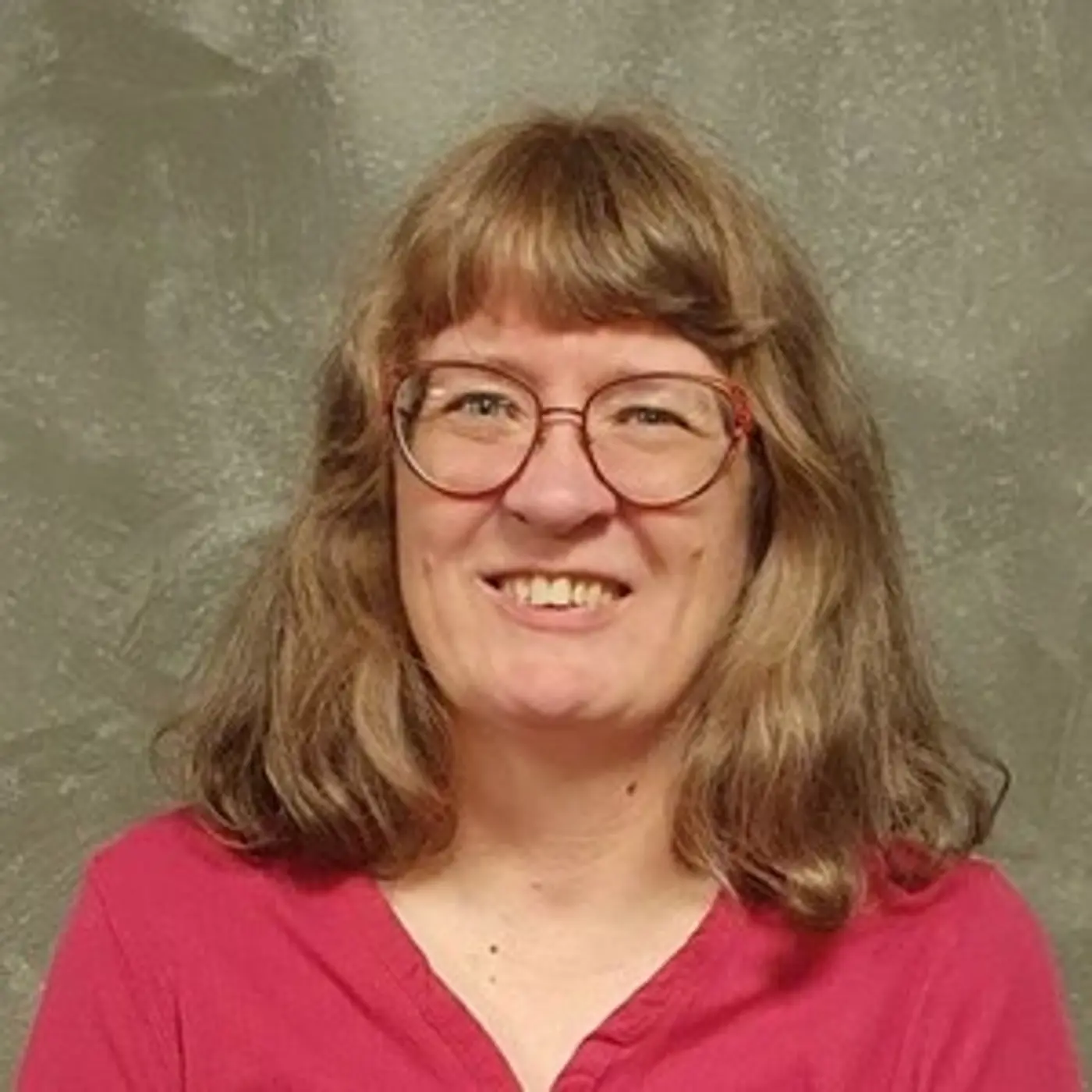 Porträttbild på en leende kvinna med glasögon.