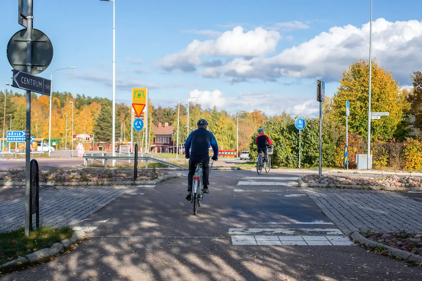 Två som cyklar över en bilväg