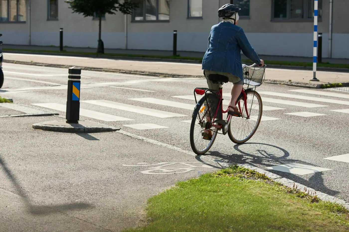 En äldre kvinna cyklar över en cykelpassage.
