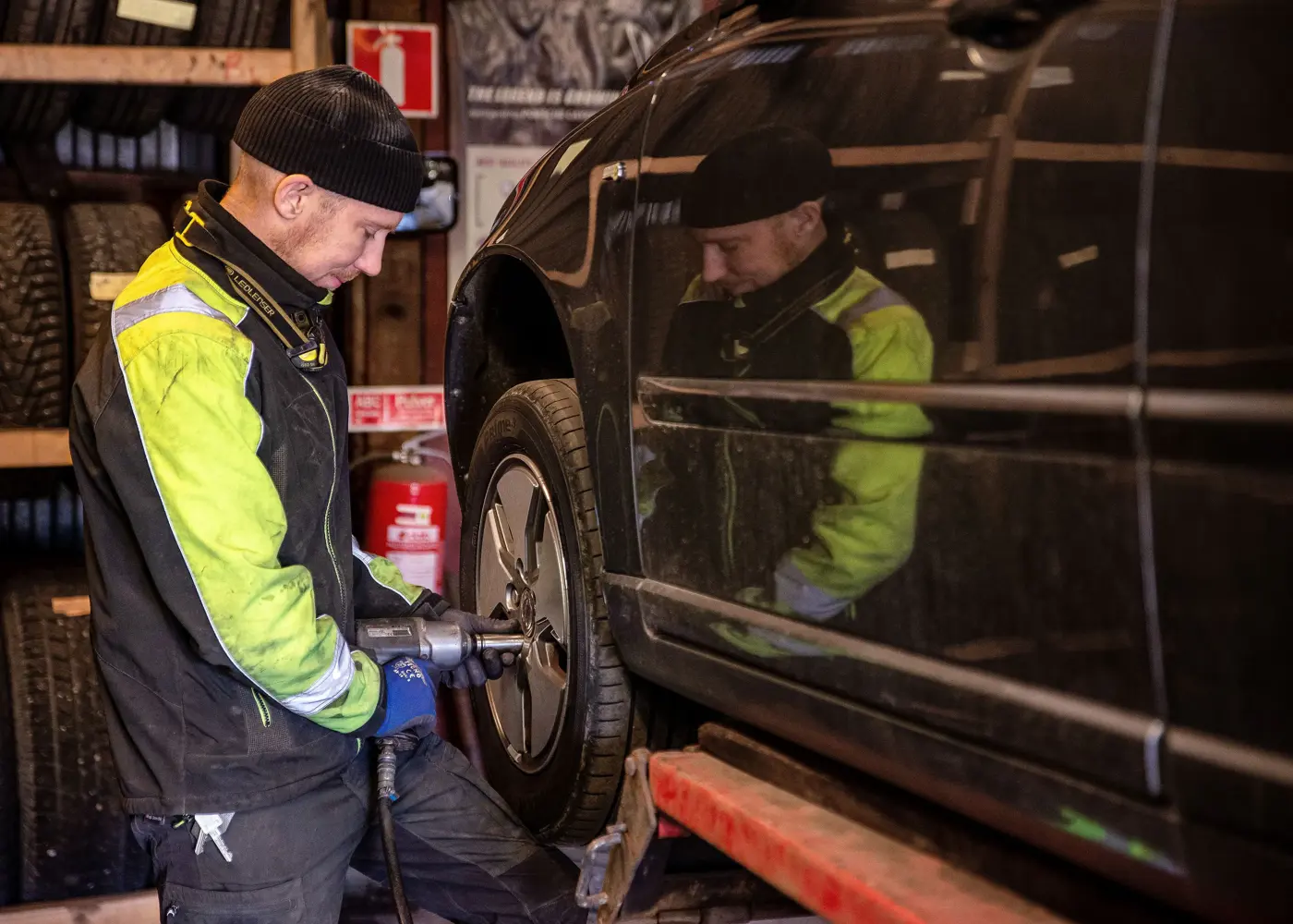 En man byter däck på en bil.