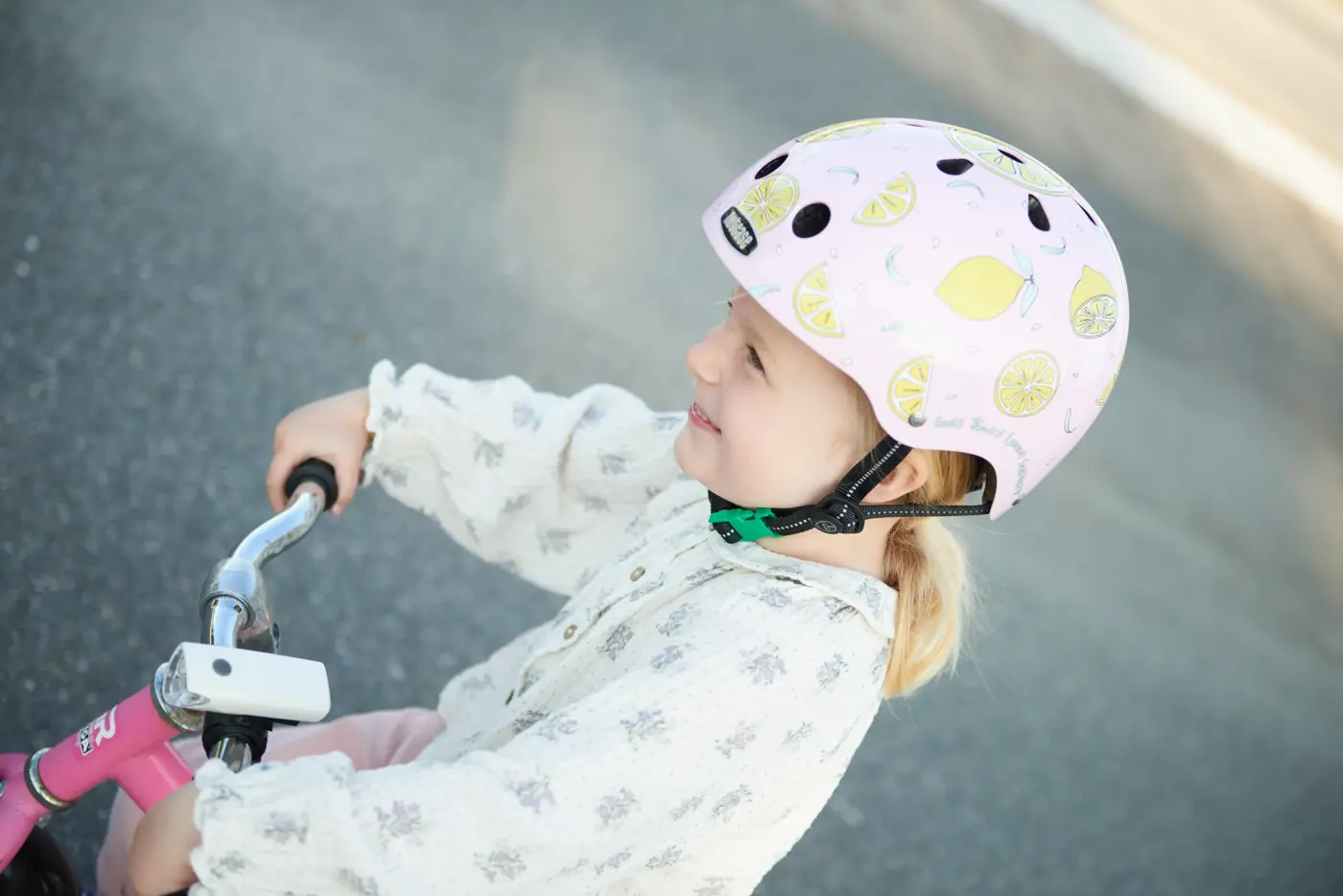 Småbarn på lekfordon med en småbarnshjälm