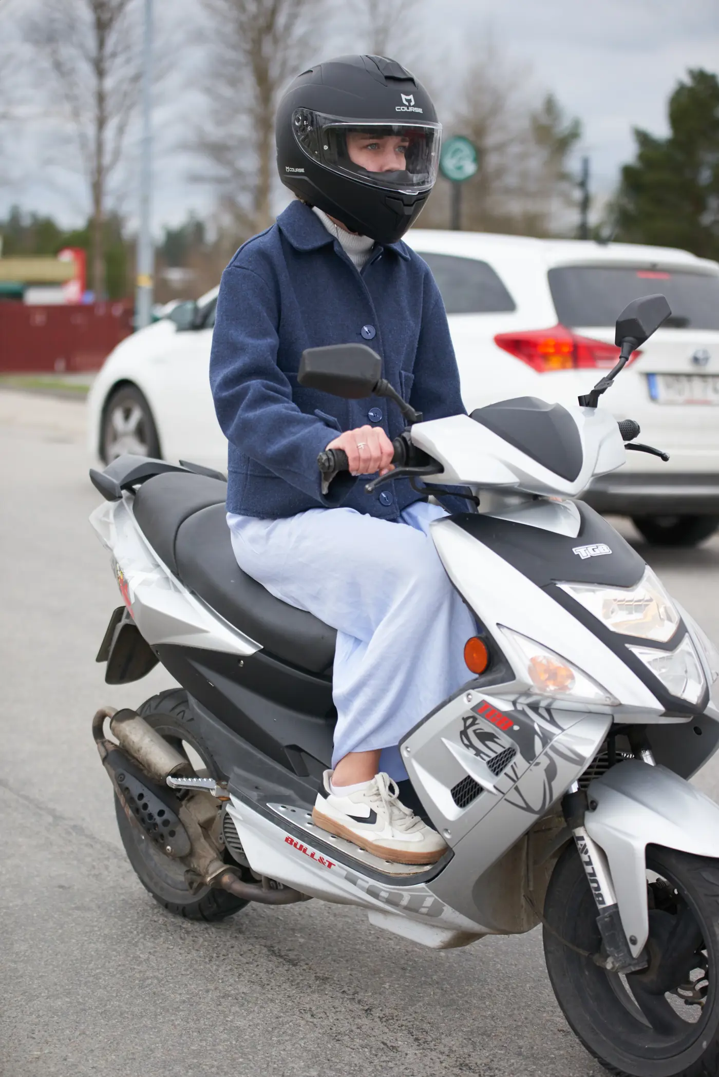 En ungdom kör moped på en asfalterad väg