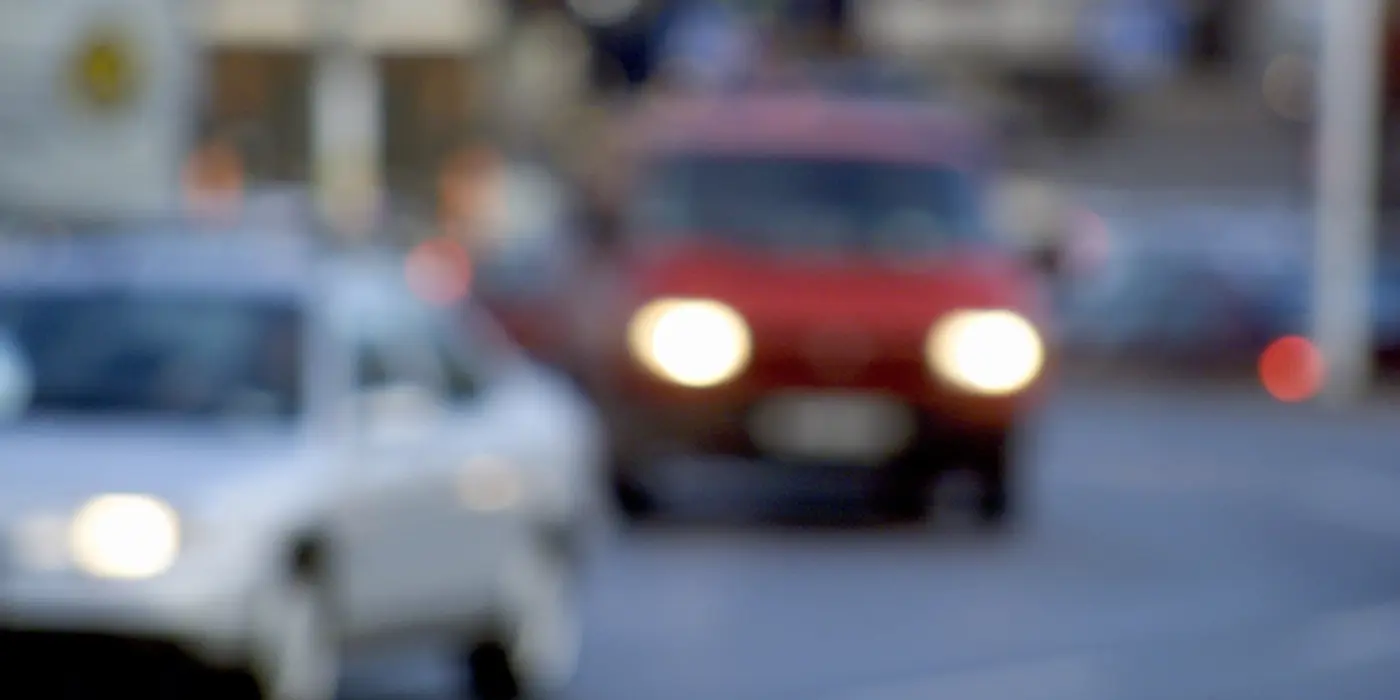 Två bilar kör på en väg. Bilden är i ofokus.