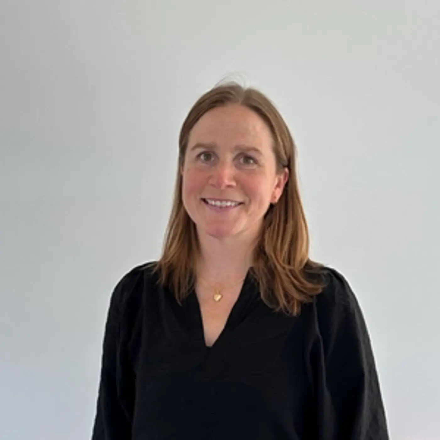 Porträttbild på en leende kvinna med svart skjorta.