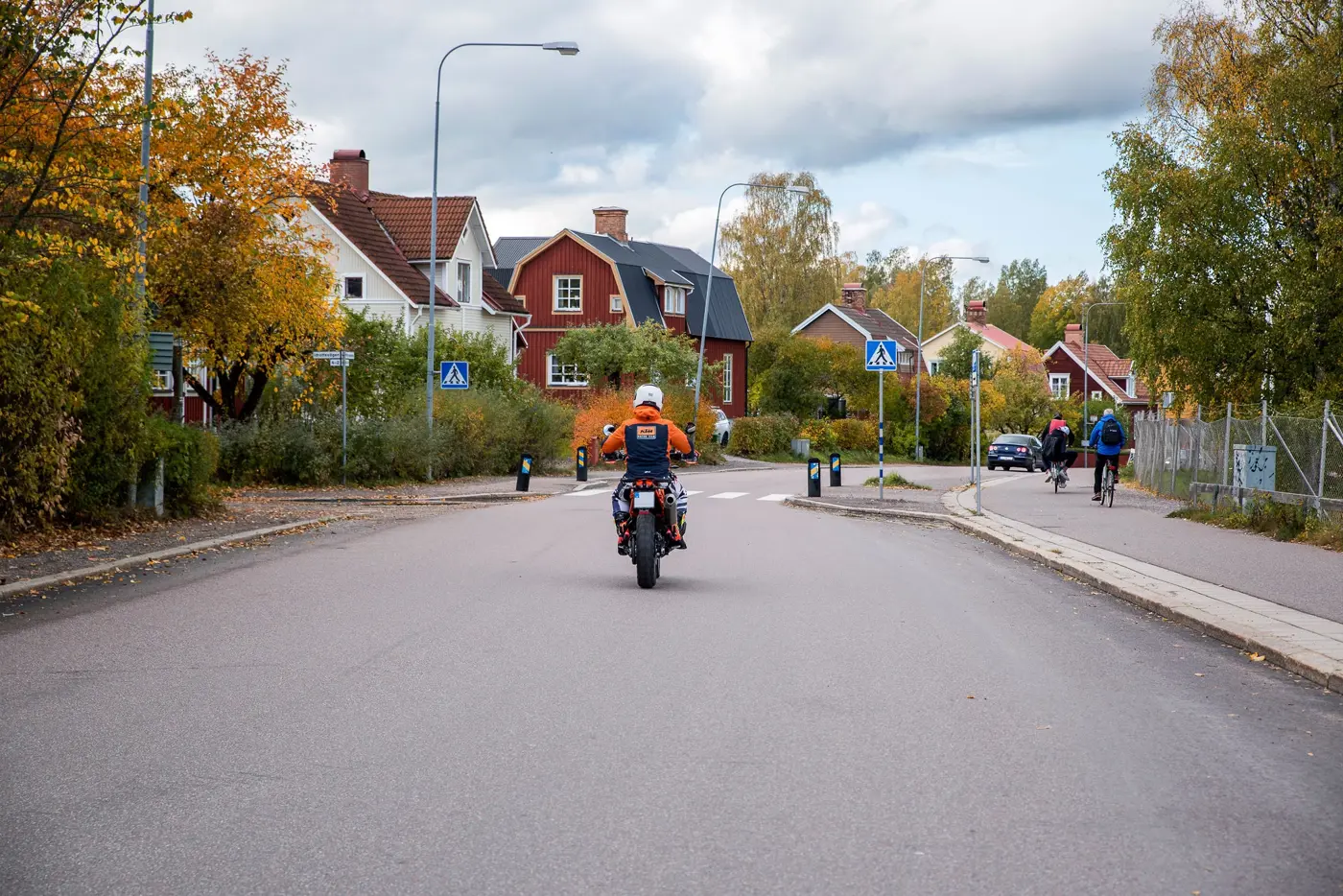 En person kör motorcykel i et bostadsområde.